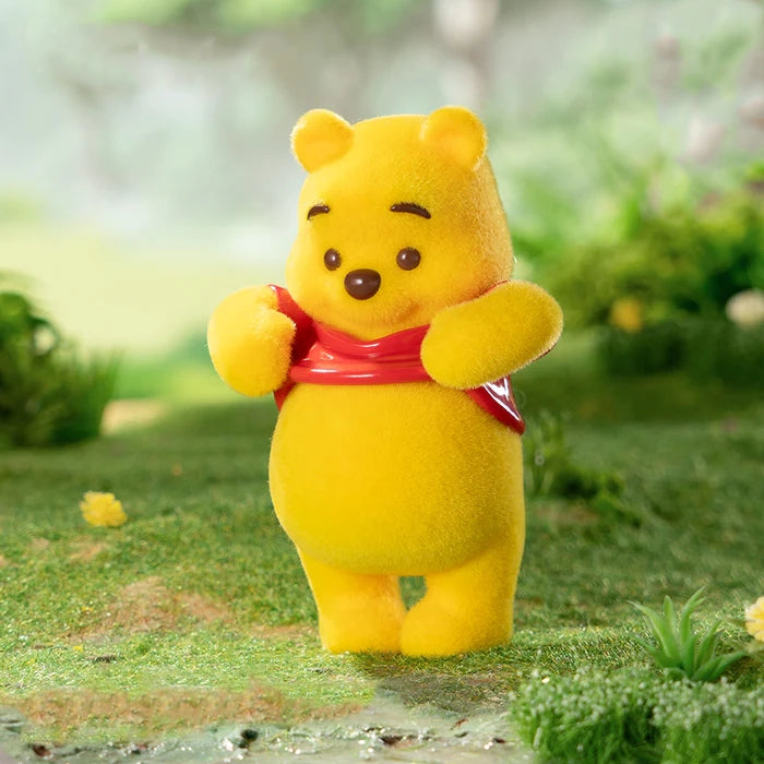 Winnie the Pooh with a red shirt standing on a grassy area