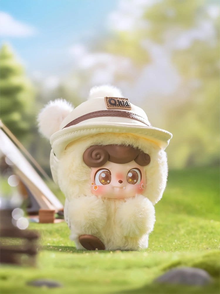 Plush Q kid go hiking toy character with a hat in a park setting