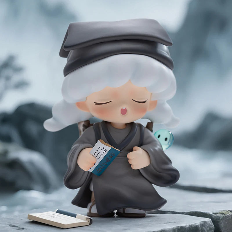 Yumo character in a gray outfit with a book and pen on a blurred natural background