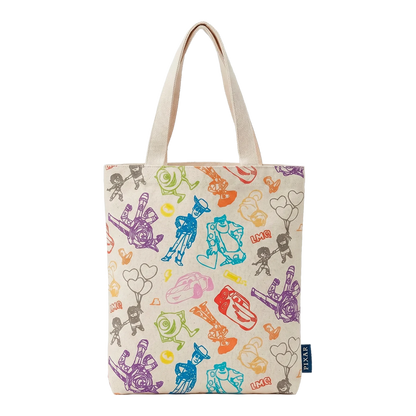 A cream canvas tote bag with a colorful all-over print of hand-drawn cartoon figures, balloons, and hearts, featuring dual cream canvas shoulder straps and a small navy blue brand tag on the lower right side.