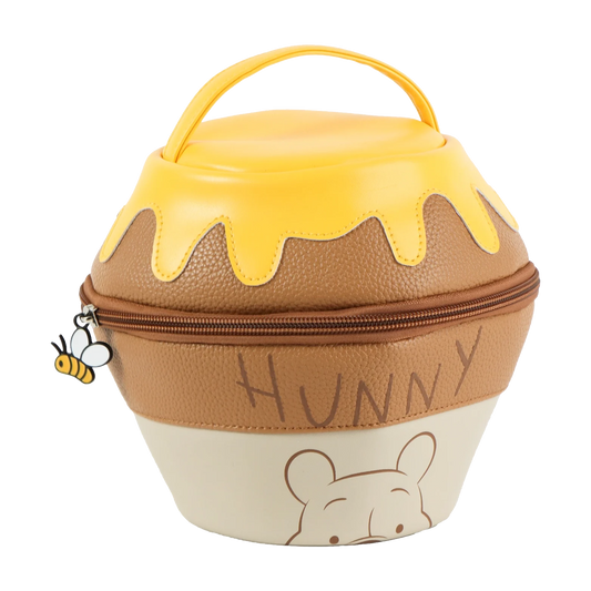 A Winnie the Pooh-style honey pot bag with a yellow honey-drip lid, brown textured body, cream lower section, zipper closure, top handle, and a small bee charm on a white background.