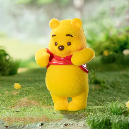 Winnie the Pooh with a red shirt standing on a grassy area