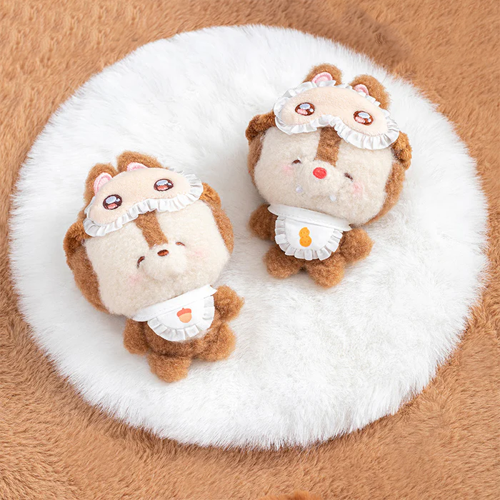 Two cute Disney squinting sleepwear blind box plush toys featuring Chip & Dale with aprons on a white fluffy surface.