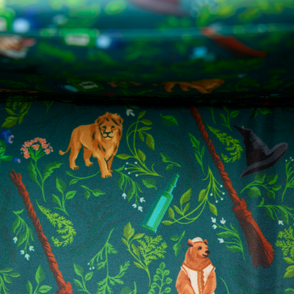 Wicked interior lining with jungle-themed design featuring animals and plants from Oz on a dark green background.