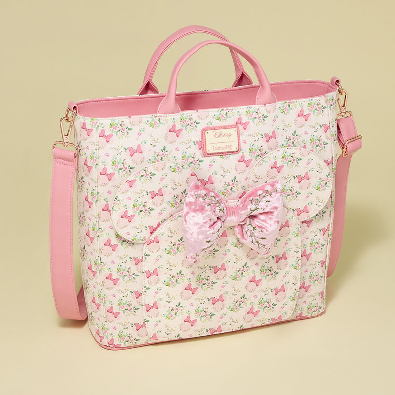 Pink floral Minnie Mouse Loungefly tote bag with a large bow on a beige background