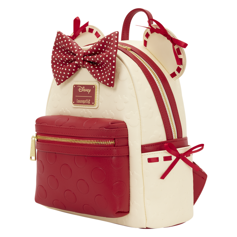 Minnie Mouse Loungefly Mini Backpack with red and white polka dot bow, gold zippers, and Disney logo on a white background