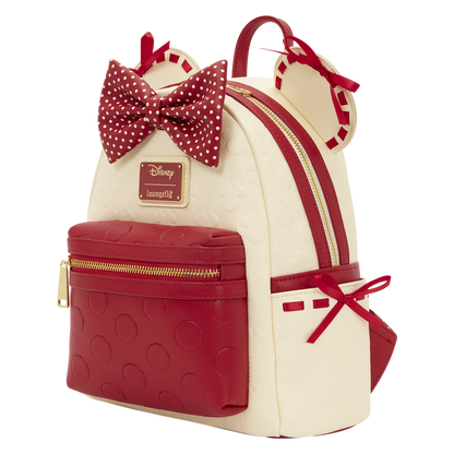 Minnie Mouse Loungefly Mini Backpack with red and white polka dot bow, gold zippers, and Disney logo on a white background