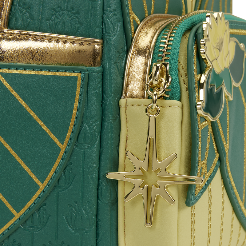 Close-up of a green and gold handbag with a star-shaped charm.