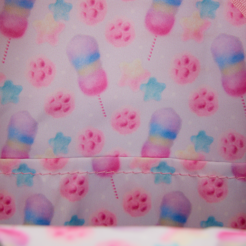 Close-up of backpack lining fabric with colorful cotton candy and star pattern on a pink background