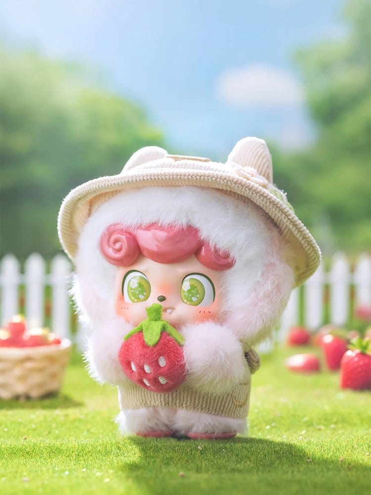 Cute Q kid pick a strawberry plush toy with a strawberry design outdoors on grass