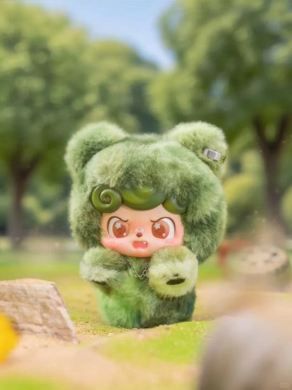 Green Q kid fire in a hole plush toy with a cartoon face in a park setting
